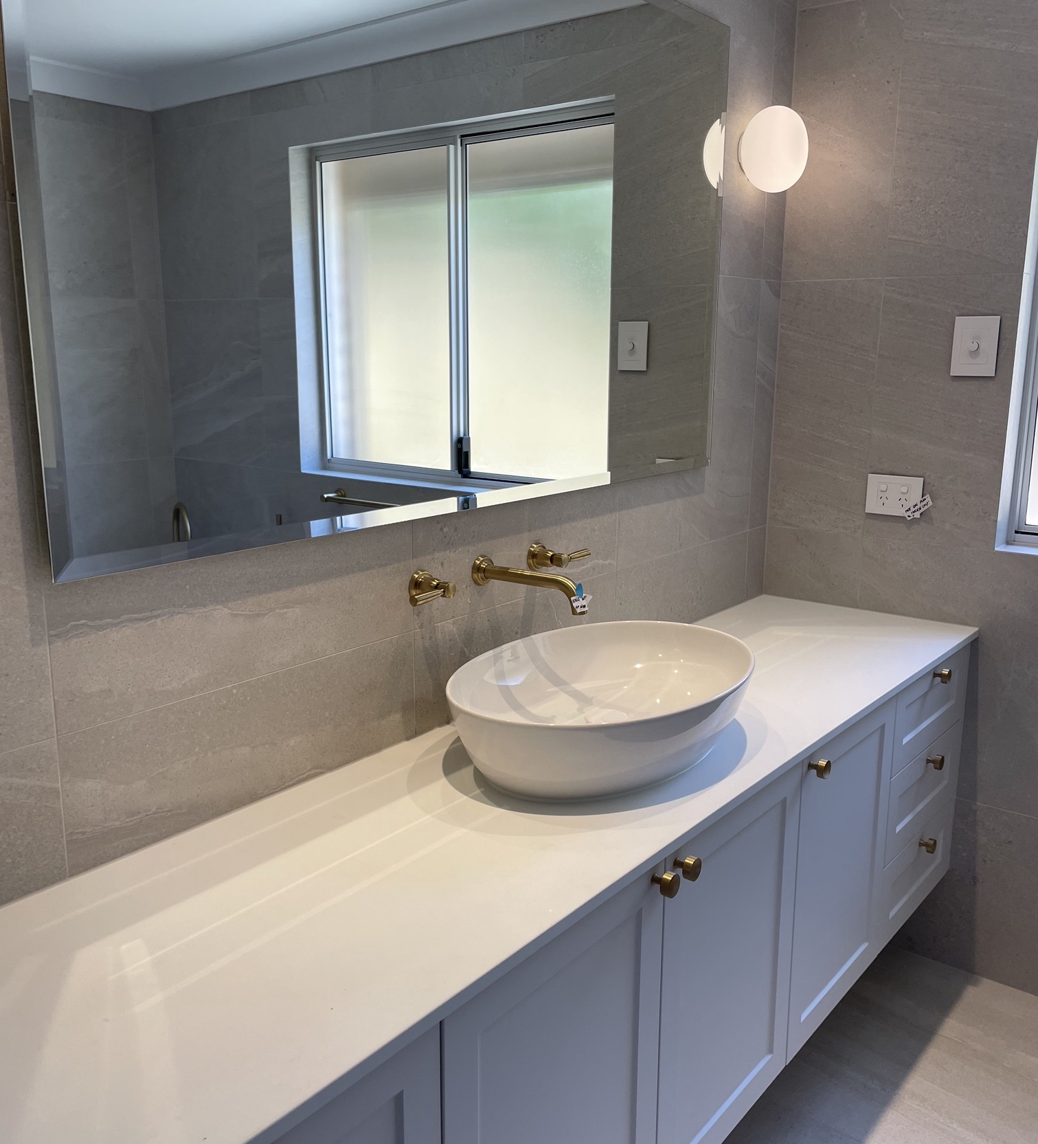 Wall-hung vanity with vessel basin and brass tapware